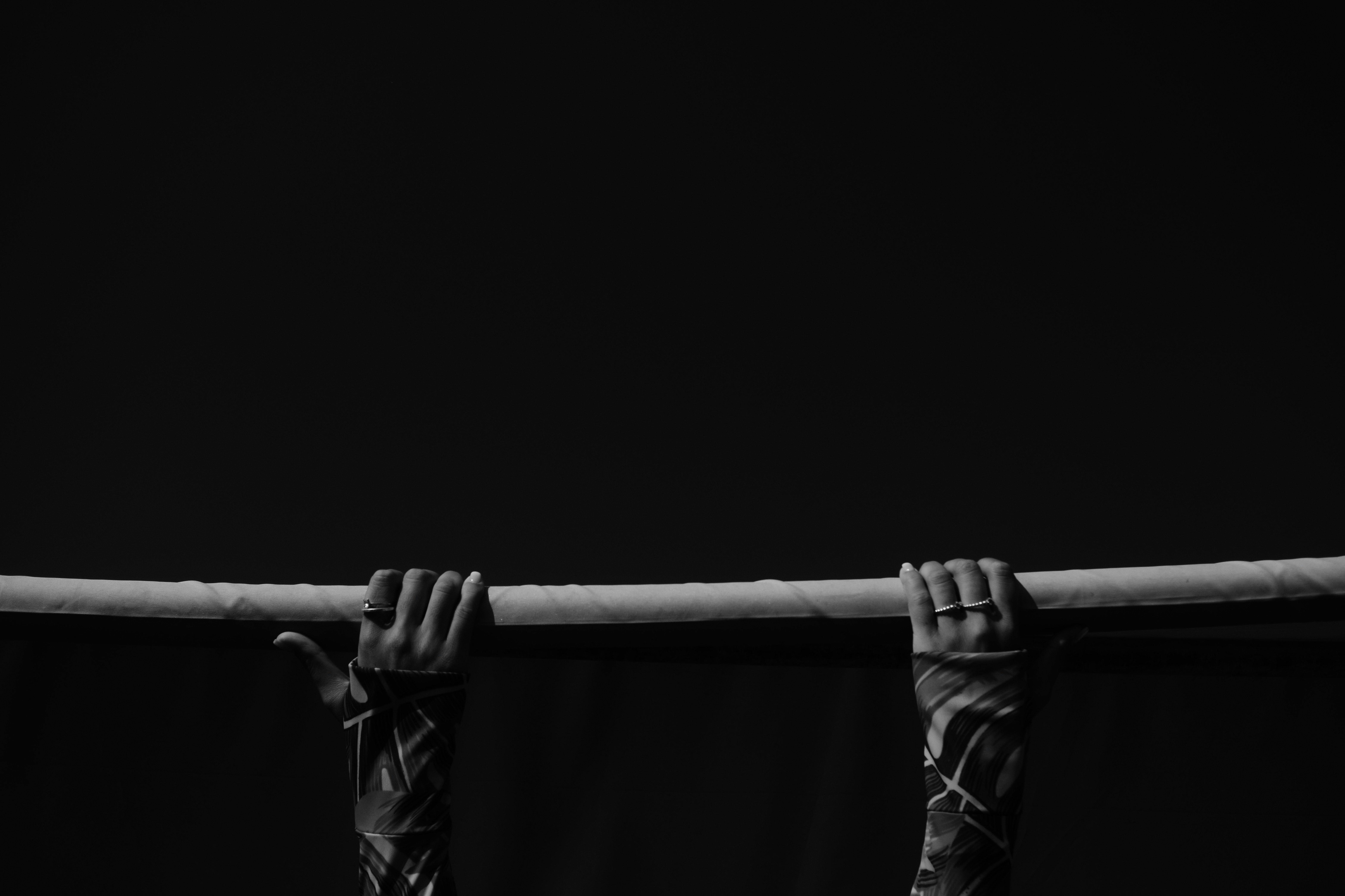 grayscale photo of person holding metal bar